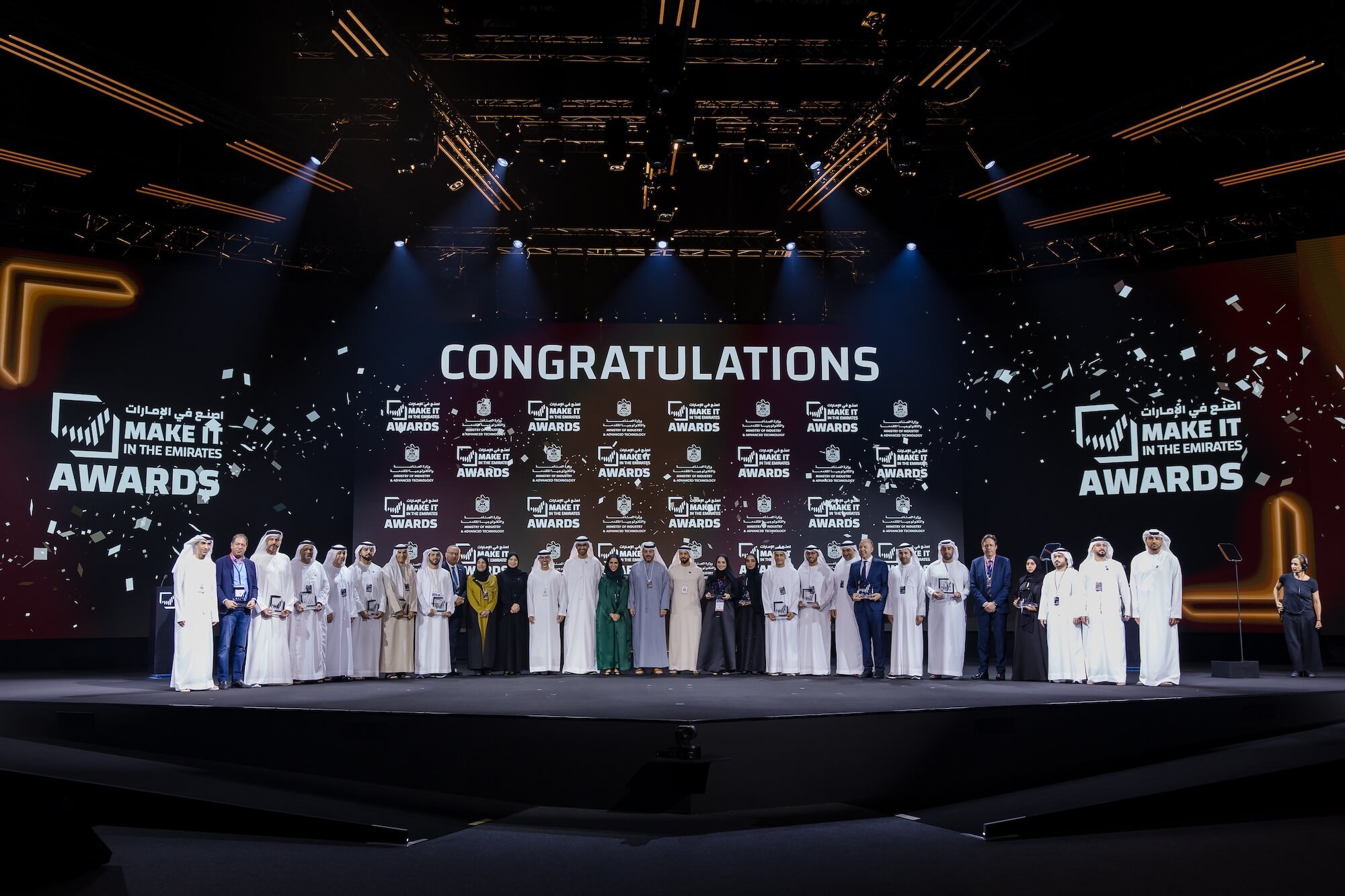 Business professionals in traditional UAE attire discussing industrial excellence and national recognition